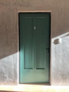 a green door with the number on it at Azul en Lavalle in Azul