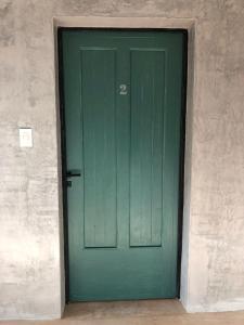 a green door in a room with a wall at Azul en Lavalle in Azul