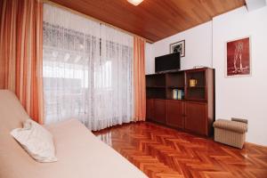 a bedroom with a bed and a tv and a window at Apartments and rooms with parking space Novalja, Pag - 6482 in Novalja