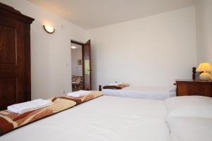 two beds in a room with white walls at Apartment Starigrad 6647a in Starigrad