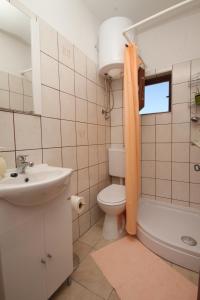 a bathroom with a toilet and a sink and a tub at Apartment Starigrad 6647a in Starigrad
