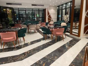 un restaurante con mesas y sillas en un edificio en Delmar Hotel Matrouh en Marsa Matruh