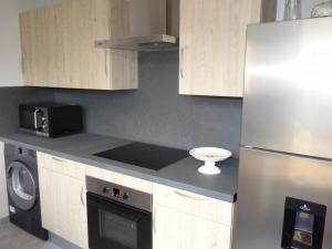 Una cocina con refrigerador de acero inoxidable y microondas. en Charmante maison en pierres à Coly - FR-1-616-19, en Maurival-Bas 6 fotos más