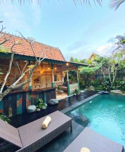 una casa con piscina frente a una casa en Honeymoon Green Villa, en Ubud