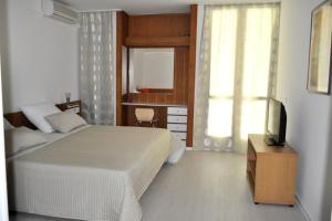 a bedroom with a bed and a desk and a television at Apartments by the sea Brela, Makarska - 6686 in Brela