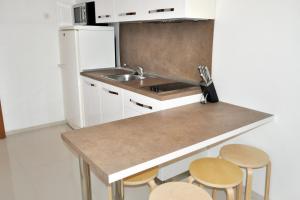 a kitchen with a counter and a sink and stools at Apartments by the sea Brela, Makarska - 6686 in Brela