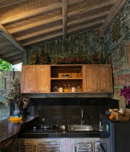 una cocina con armarios de madera y fregadero en Honeymoon Green Villa, en Ubud