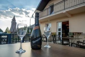 a bottle of wine and two glasses on a table at Gazdinstvo Popovic,Kucka Korita-Podgorica in Podgorica