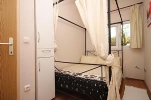 ein Schlafzimmer mit einem Etagenbett und einem Fenster in der Unterkunft Apartments by the sea Funtana, Porec - 6905 in Funtana