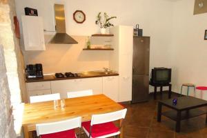a kitchen with a wooden table and a kitchen with a refrigerator at Apartments by the sea Funtana, Porec - 6905 in Funtana