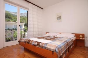 a bedroom with a bed and a large window at Apartments and rooms with parking space Podgora, Makarska - 6790 in Podgora