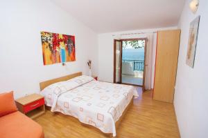a bedroom with a bed and a view of the ocean at Apartments by the sea Podgora, Makarska - 6673 in Podgora