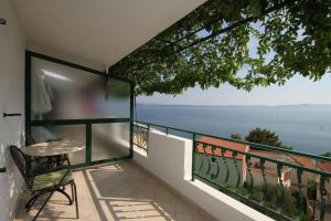 a balcony with a table and a view of the ocean at Apartments by the sea Podgora, Makarska - 6673 in Podgora