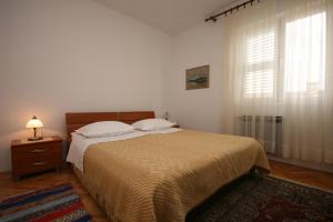 a bedroom with a large bed and a window at Apartments with a parking space Biograd na Moru, Biograd - 6446 in Biograd na Moru