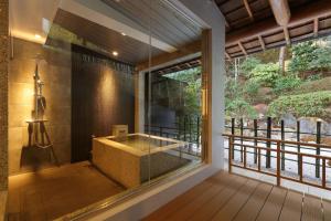 uma casa de banho com uma grande janela e uma banheira em Arima Onsen Taketoritei Maruyama em Kobe