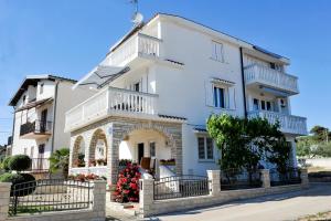 une grande maison blanche avec une clôture devant elle dans l'établissement Apartments with a parking space Sukosan, Zadar - 6131, à Sukošan