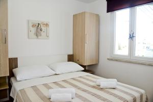 - une chambre avec un lit et 2 oreillers blancs dans l'établissement Apartments with a parking space Sukosan, Zadar - 6131, à Sukošan