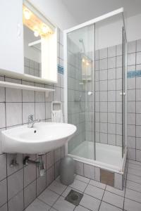 La salle de bains est pourvue d'un lavabo et d'une douche. dans l'établissement Apartments with a parking space Sukosan, Zadar - 6131, à Sukošan