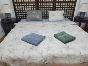 a bed with two pillows and two towels on it at Lola's Guest House in Mactan