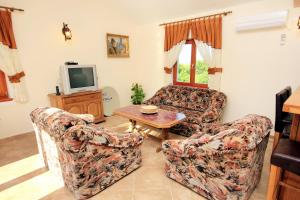 a living room with two chairs and a tv at Family friendly house with a swimming pool Valtura, Pula - 6913 in Ližnjan