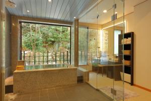 ein Bad mit einer Badewanne und einem großen Fenster in der Unterkunft Arima Onsen Taketoritei Maruyama in Kōbe