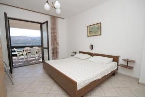 a bedroom with a bed and a balcony with a table at Apartments with a parking space Pag - 6529 in Pag