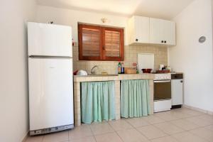 a kitchen with white appliances and a white refrigerator at Secluded fisherman's cottage Cove Statival, Kornati - 8164 in Pristanišće