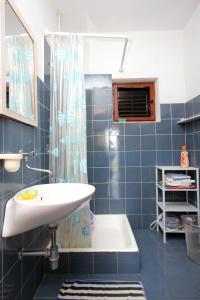 a blue tiled bathroom with a sink and a shower at Secluded fisherman's cottage Cove Suha Punta, Kornati - 8168 in Pinizelić