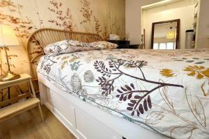 - une chambre avec un lit et une couette à fleurs dans l'établissement Le Rive Droite, à Nantes