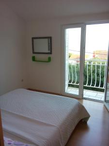 - une chambre avec un lit et une fenêtre avec un balcon dans l'établissement Apartments with WiFi Bol, Brac - 8736, à Bol
