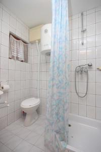 a bathroom with a toilet and a shower curtain at Studio Kali 8202a in Kali