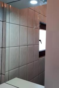 a bathroom with a tiled wall and a window at Studio Kali 8202a in Kali +17 photos