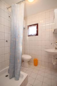 a bathroom with a toilet and a shower curtain at Apartments by the sea Kali, Ugljan - 8202 in Kali