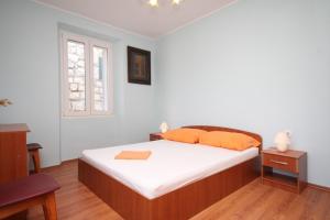 a bedroom with a bed with white sheets and a window at Holiday house Lastovo - 8289 in Lastovo