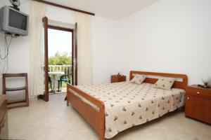 een slaapkamer met een bed, een televisie en een balkon bij Apartments by the sea Zaklopatica, Lastovo - 8340 in Lastovo