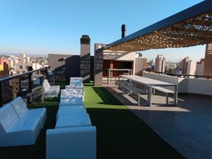 eine Dachterrasse mit weißen Bänken auf einem Gebäude in der Unterkunft Brasil flats-Nueva Cordoba in Cordoba