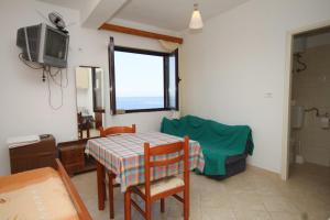 een woonkamer met een tafel en een televisie bij Apartments by the sea Zaklopatica, Lastovo - 8340 in Lastovo
