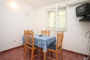 ein Esszimmer mit einem Tisch und Stühlen sowie einem TV in der Unterkunft Apartment Pasadur 8337g in Ubli