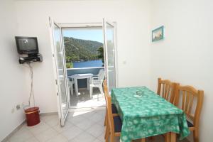 ein kleines Esszimmer mit einem Tisch und einem Balkon in der Unterkunft Apartments by the sea Pasadur, Lastovo - 8337 in Ubli