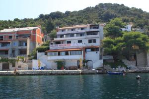 a building on the shore of a body of water at Apartments by the sea Zaklopatica, Lastovo - 8325 in Lastovo