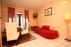 a living room with a red bed and a table at Apartments by the sea Zaklopatica, Lastovo - 8325 in Lastovo