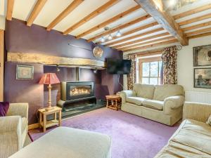 a living room with a couch and a fireplace at Pen Y Bryn Cottage in Llandudno Junction