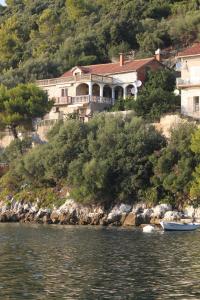 a large house on a hill next to the water at Apartments by the sea Ubli, Lastovo - 8344 in Ubli