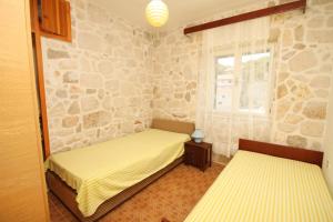 duas camas num quarto com uma parede de pedra em Seaside holiday house Lucica, Lastovo - 8348 em Lastovo