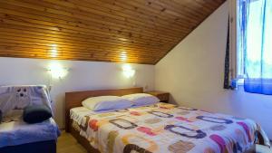 ein Schlafzimmer mit einem Bett und einer Holzdecke in der Unterkunft Apartment Ugljan 8241e in Ugljan