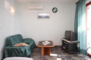 ein Wohnzimmer mit einem grünen Sofa und einem Tisch in der Unterkunft Apartments by the sea Skrivena Luka, Lastovo - 8352 in Lastovo