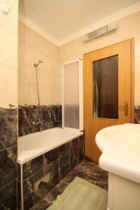 ein Badezimmer mit einer Dusche, einer Badewanne und einem Waschbecken in der Unterkunft Apartments by the sea Skrivena Luka, Lastovo - 8352 in Lastovo