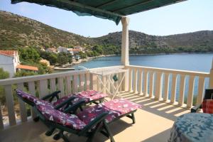 a balcony with two chairs and a view of the water at Apartments by the sea Skrivena Luka, Lastovo - 8352 in Lastovo