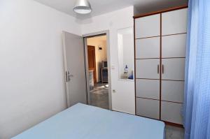 a white bedroom with a bed and a closet at Studio Pasadur 8351a in Ubli