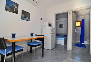 a kitchen with a table and chairs and a refrigerator at Studio Pasadur 8351a in Ubli